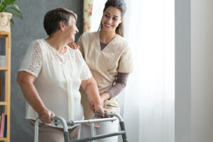 a nurse helping an old woman with a walker